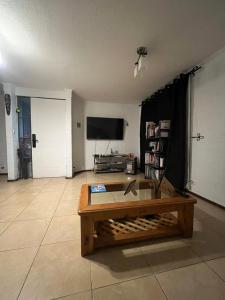 a living room with a coffee table and a flat screen tv at Casa cerca del Aeropuerto - Tu Espacio RE in Santiago
