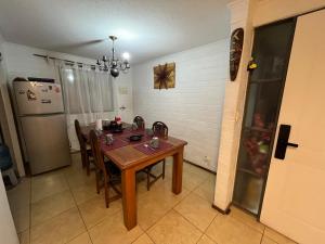 a kitchen with a table and chairs and a refrigerator at Casa cerca del Aeropuerto - Tu Espacio RE in Santiago