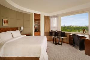 a hotel room with a bed and a large window at The Park Tower Knightsbridge, a Luxury Collection Hotel, London in London +84 photos