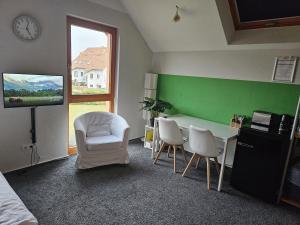 a room with a green wall and a table and chairs at Maisonette-Ferienzimmer Am Backhausgarten in Flonheim