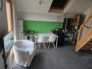 a room with a table and chairs and a green wall at Maisonette-Ferienzimmer Am Backhausgarten in Flonheim