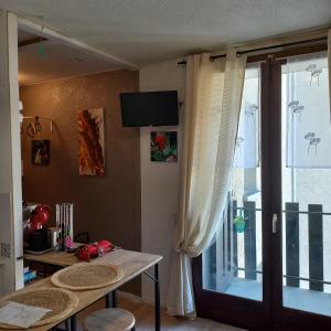 a dining room with a table and a sliding glass door at Studio SAFARI in Luchon