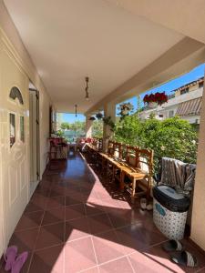 a porch with tables and chairs on a patio at Vlora Backpackers Hostel & Bar LUNGOMARE in Vlorë