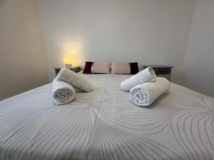 a white bed with three pillows on it at Escale à Villeneuve in Villeneuve-sur-Yonne