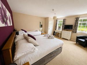 a large bedroom with two beds and a television at The Riverside in Boscastle