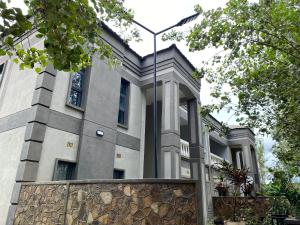 a building with a stone fence in front of it at The Stone Duplex Apartment House 1 in Lilongwe