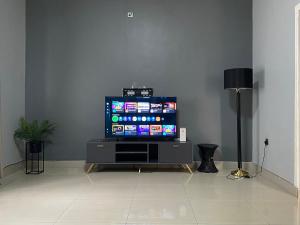 a flat screen tv sitting on a stand in a living room at The Stone Duplex Apartment House 1 in Lilongwe