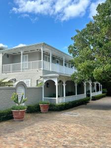 a large white house with a large porch at Vivere in Hermanus