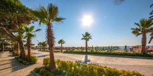 a street with palm trees and the beach at Nuovo Sun Golem in Golem