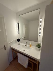 a bathroom with a sink and a large mirror at Casa Nena Es Calo in Es Caló