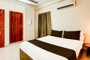 a hotel room with a bed and a window at Hotel O Vyb Hotels in Hyderabad