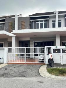 a house with a white fence in front of it at Puteri Elaisha Homestay in Batu Arang