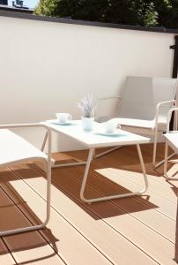 a white table and two chairs on a patio at Downtown Apartments Podpromie Monica with UNDERGROUND PARKING in Rzeszów
