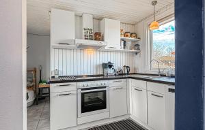a kitchen with white cabinets and a sink at 2 Bedroom Stunning Home In Roslev in Roslev