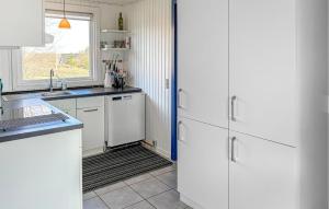 a kitchen with white cabinets and a window at 2 Bedroom Stunning Home In Roslev in Roslev