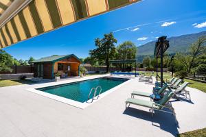 a swimming pool with lounge chairs and a house at Oria Retreat in Danilovgrad