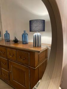 a table with a lamp and two blue vases on it at Charmante Maison Vue mer Panoramique à Coti-Chiavari in Coti-Chiavari