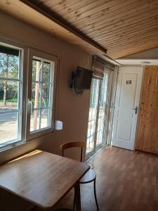 a room with a wooden table and some windows at Sosnowa Polana in Lipinki +13 photos
