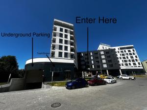 a parking lot with cars parked in front of a building at Downtown Apartments Podpromie Monica with UNDERGROUND PARKING in Rzeszów +9 photos
