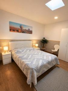 a bedroom with a bed and two tables and two lamps at Costacabana Sea Apartment in Almería
