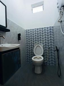 a bathroom with a toilet and a sink at Losd Village Cottage in Kuala Perlis