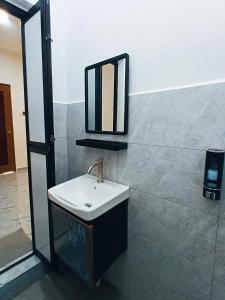 a bathroom with a sink and a mirror on the wall at Losd Village Cottage in Kuala Perlis