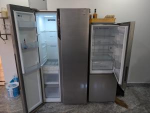 an empty refrigerator with its door open in a kitchen at Goa Paradise House in Canacona