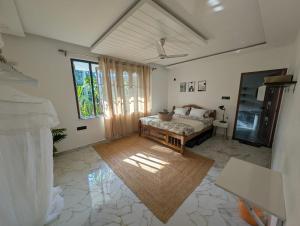 a bedroom with a bed and a couch in a room at Goa Paradise House in Canacona