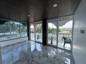 an empty room with glass doors and a table and chair at Goa Paradise House in Canacona