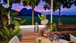 a table with a bath tub with a view of a lake at Khao Poon Camping in Kanchanaburi City