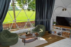 a living room with two chairs and a table and a television at Khao Poon Camping in Kanchanaburi City