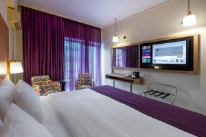 a hotel room with a bed and a flat screen tv at Polis Grand Hotel in Athens +133 photos