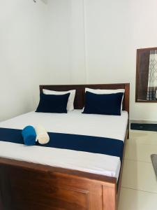 a bed with blue and white pillows in a room at Wagon Inns anuradhapura in Anuradhapura