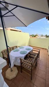 a table and chairs under an umbrella on a patio at Olivia in Barrio-Mar
