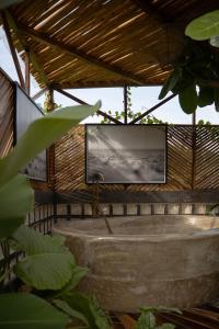 a flat screen tv in a building with a tub at The Salty Jungle in Cijulang Nusawiru Airport +8 photos