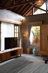 a bedroom with a flat screen tv and a bed at The Salty Jungle in Cijulang Nusawiru Airport