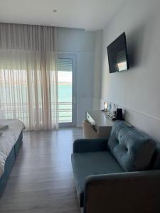 a bedroom with a couch and a tv and a bed at Ventus Harbor Hotel in Durrës