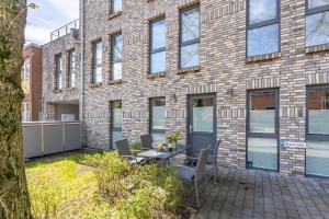 a patio with a table and chairs in front of a brick building at SEASIDE APT. - BEACHHOUSE SOUL in Eckernförde