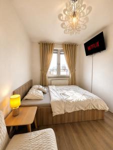 a bedroom with a bed and a chandelier at Downtown Apartments Family&Friends in Rzeszów