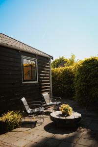 two chairs and a table in a yard at B&B de Lytse Geast in Tietjerk