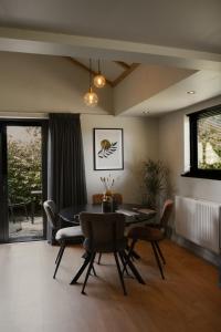 a dining room with a table and chairs at B&B de Lytse Geast in Tietjerk