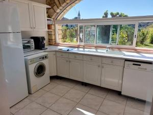 a kitchen with a sink and a dishwasher at Le Gite in Labastide-de-Virac