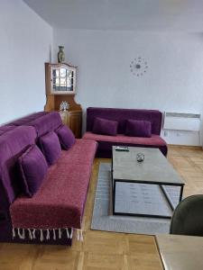 a living room with a purple couch and a table at Golden view apartman in Bar