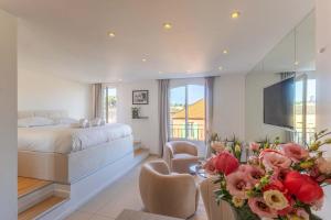 a bedroom with a bed and a television and flowers at Le Semiramis l Central & Views l Shellter Rentals in Saint-Tropez
