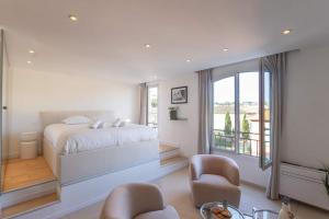 a white bedroom with a bed and a balcony at Le Semiramis l Central & Views l Shellter Rentals in Saint-Tropez