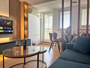 a living room with a couch and a table with wine glasses at Puro Center in Ohrid