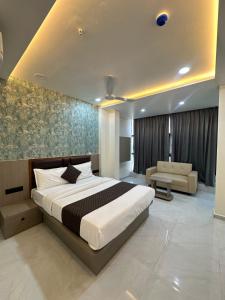 a bedroom with a large bed and a couch at Hotel Fortune in Ankleshwar