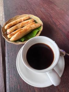 a cup of coffee and a basket of bagels on a table at Livin didesa in Munduk