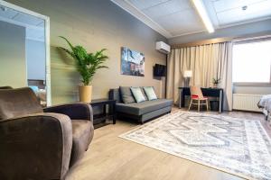 a living room with a couch and a chair at Hotelli Viikinhovi in Keuruu