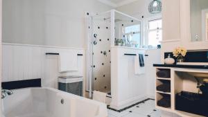 a white bathroom with a tub and a sink at Authentic Mossel Bay in Mossel Bay +30 photos